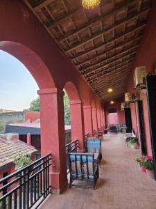 eine Terrasse mit Bänken in einem Gebäude mit Balkon in der Unterkunft Hôtel Niwa in Gorée