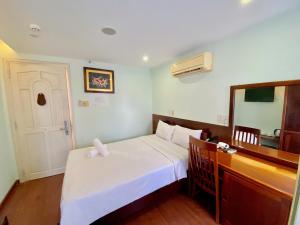 1 dormitorio con cama, tocador y espejo en Art Deluxe Hotel, en Nha Trang