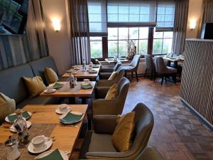 een restaurant met houten tafels, stoelen en ramen bij Hotel Wernerwald in Cuxhaven