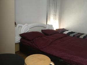 Rooms Struga في ستروغا: غرفة نوم بسرير لحاف احمر وطاولة