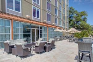 un patio al aire libre con sillas, mesas y sombrillas en DoubleTree by Hilton Hotel Biloxi, en Biloxi