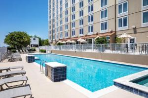 una piscina con sillas y un edificio en DoubleTree by Hilton Hotel Biloxi, en Biloxi