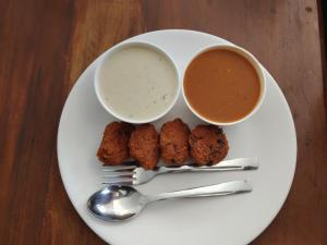 einen Teller mit Fleischbällchen und eine Schüssel Dip-Soße und Dip in der Unterkunft Hsquare Hotel Andheri West in Mumbai