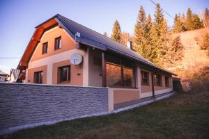 ein Haus mit einer Backsteinmauer daneben in der Unterkunft Vilka Stefi in Ždiar