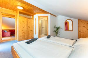 Duas camas num quarto com paredes de madeira em Sonnberg Lodge em Maria Alm am Steinernen Meer