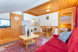 uma sala de estar com um sofá vermelho e uma mesa em Sonnberg Lodge em Maria Alm am Steinernen Meer