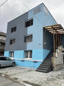 a blue building with a car parked in front of it at IQ Apartments in Prešov