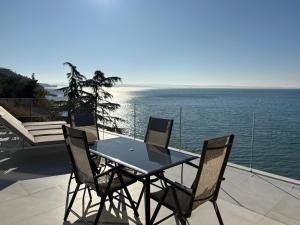 un tavolo e sedie su un patio con vista sull'oceano di Seaside Resort a Trieste