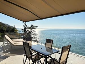 un tavolo e sedie su un patio con vista sull'oceano di Seaside Resort a Trieste