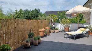 a patio with potted plants and a wooden fence at Beletage in Neuwied