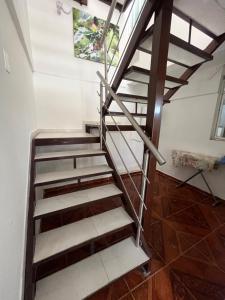 a spiral staircase in a room with white walls and wooden floors at Céntrico Aparta-estudio in Pereira