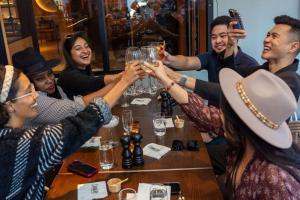 un grupo de personas sentadas alrededor de una mesa bebiendo champán en Hilton Garden Inn Calgary Downtown, en Calgary