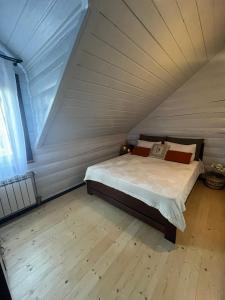 ein Schlafzimmer mit einem Bett im Dachgeschoss in der Unterkunft Yellow House in Pilipets