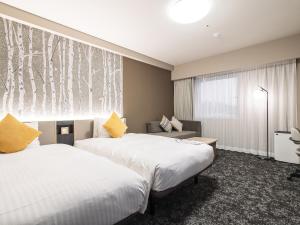 Giường trong phòng chung tại Richmond Hotel Obihiro Ekimae