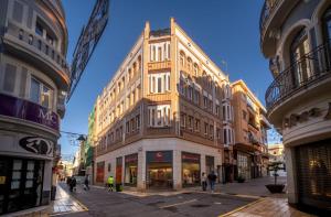 a tall building in the middle of a street at William Martin Apartments in Huelva