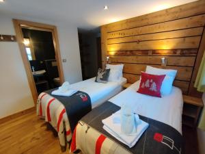 2 camas en una habitación con paredes de madera en MORZINE GUEST CHALET HYPERCENTRE Hot tub & Sauna, en Morzine