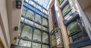 un grand bâtiment en verre avec des plantes dans l'établissement Best Western Plus Le Picardy, à Saint-Quentin