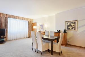 a dining room with a table and white chairs at The Q Quadro City Hotel in Karlsruhe