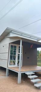 een tiny house met een veranda en een bank voor de deur bij Malgudi Farms in Bangalore