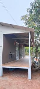 een groot gebouw met een veranda en een boom bij Malgudi Farms in Bangalore