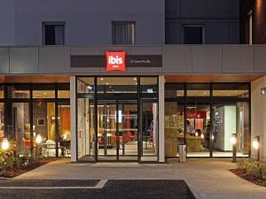 un magasin à l'avant d'un bâtiment muni d'un panneau d'affichage dans l'établissement Ibis Saint-Genis-Pouilly Genève, à Saint-Genis-Pouilly