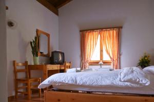 - une chambre avec un lit, un bureau et une fenêtre dans l'établissement Hotel Restaurant Walserhof, à Medels im Rheinwald