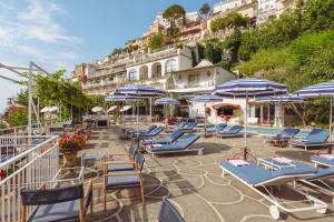 um grupo de espreguiçadeiras e guarda-sóis num pátio em Hotel Poseidon em Positano