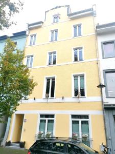 un edificio giallo con un'auto parcheggiata di fronte di Rheinufer am Hindenburgpark a Bingen am Rhein