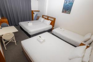 Tempat tidur dalam kamar di Gosford Inn Motel