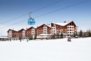 mensen op een skilift voor een skigebied bij Kempinski Hotel Grand Arena Bansko in Bansko