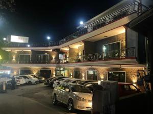 een parkeerplaats voor een gebouw 's nachts bij Mussiaree Hotel in Murree