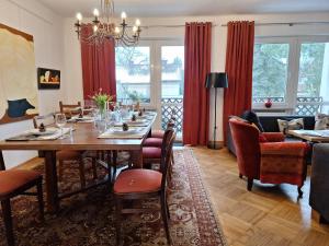 sala de estar con mesa de comedor y cortinas rojas en Dom Nałęczowski, en Nałęczów