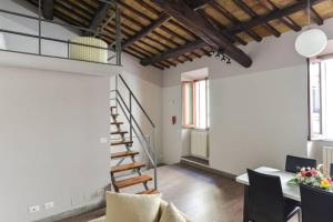 a living room with a staircase and a table and chairs at Navona Rubens Lodge in Rome