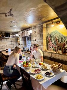 een groep mensen aan een tafel met eten bij Resort Mezná in Hřensko