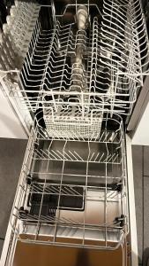 an empty dishwasher with white baskets on the rack at Quiet Flat in Nature in Lugano in Lugano