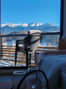 a bedroom with a bed and a high heel shoe on a chair at Touch the Sky in Moieciu de Jos