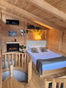 a bedroom with a bed and a fireplace in a log cabin at Hotel Borjomi Verde in Borjomi