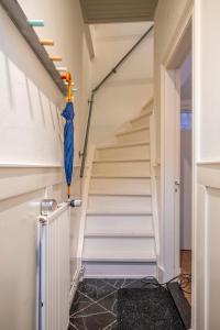 eine Treppe mit blauem Regenschirm in einem Haus in der Unterkunft Suite aan de A in Groningen