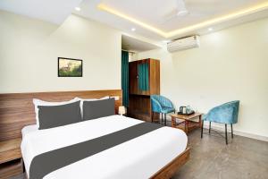 een slaapkamer met een bed en een tafel en stoelen bij Hotel O GAYATHRI METRO DELUXE in Bangalore