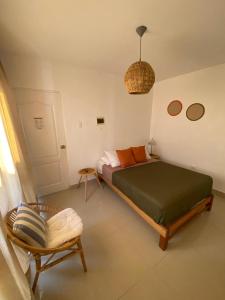 een slaapkamer met een bed en een stoel erin bij Hostel Killamoon Centro in Paracas