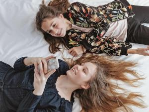 twee meisjes die op een bed liggen met een mobiele telefoon bij ibis Hotel Brussels Expo Atomium in Brussel