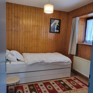 - une chambre avec un lit dans un mur en bois dans l'établissement Appartement Randogne avec grande terrasse, à Crans-Montana