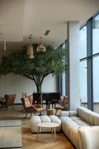 a living room with a couch and a tree at Mazurski Raj - Hotel, Marina & Spa in Ruciane-Nida