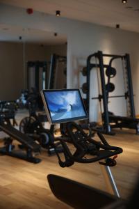 a gym with a laptop computer on a treadmill at Mazurski Raj - Hotel, Marina & Spa in Ruciane-Nida