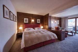 a hotel room with a large bed and a desk at Haldenhof in Lech am Arlberg