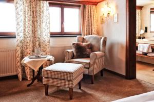 a hotel room with a chair and a table at Haldenhof in Lech am Arlberg