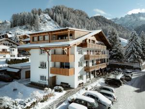 budynek z samochodami zaparkowanymi na parkingu w obiekcie Apartment Villa Stefania w mieście Selva di Val Gardena