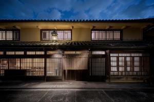 un vecchio edificio con cancelli e un lampione di YORUYA a Kurashiki