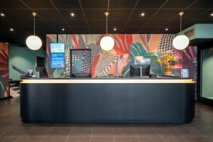 un vestíbulo con un mostrador con una pared colorida en Thon Hotel Rotterdam City Centre, en Róterdam