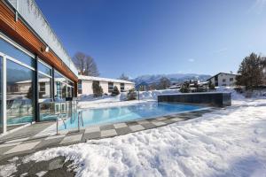 una casa con piscina en la nieve en Hotel-Restaurant Grimmingblick, en Bad Mitterndorf